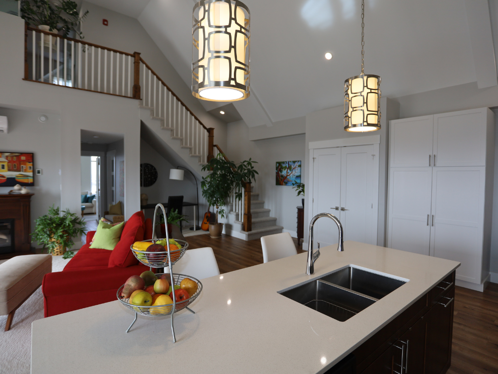 a view of a kitchen with a sink and a living room with a staircase