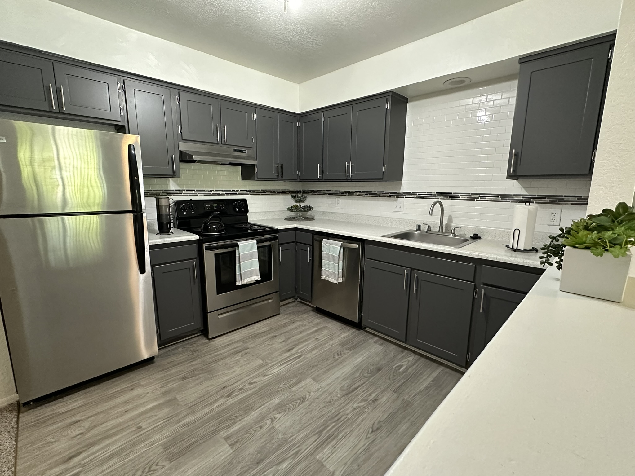 a kitchen with black cabinets and stainless steel appliances