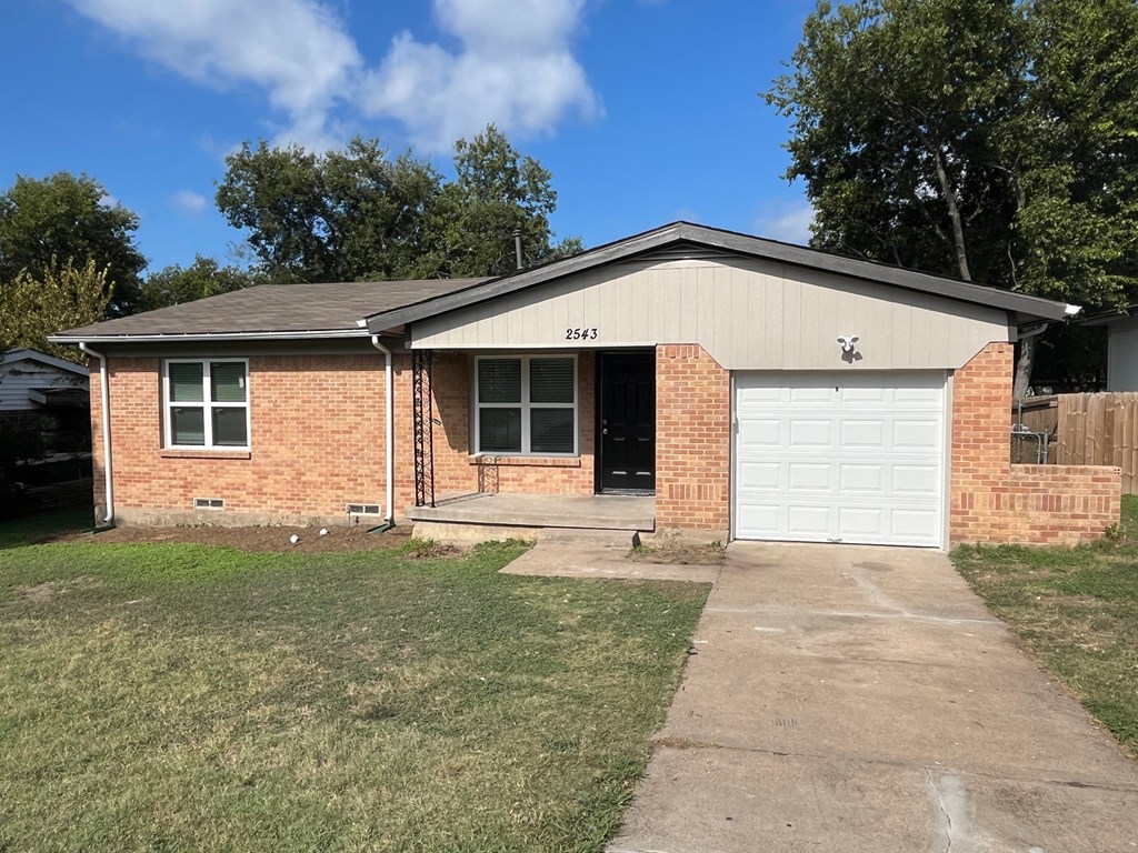 A house with a garage and a driveway in front.