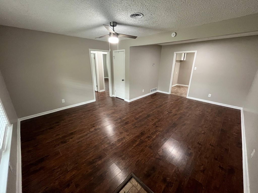 A room with wooden floors and a ceiling fan.