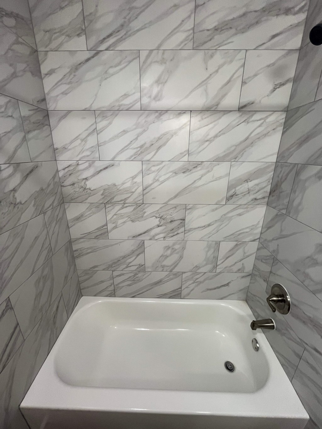 A white sink in a marble tiled bathroom.
