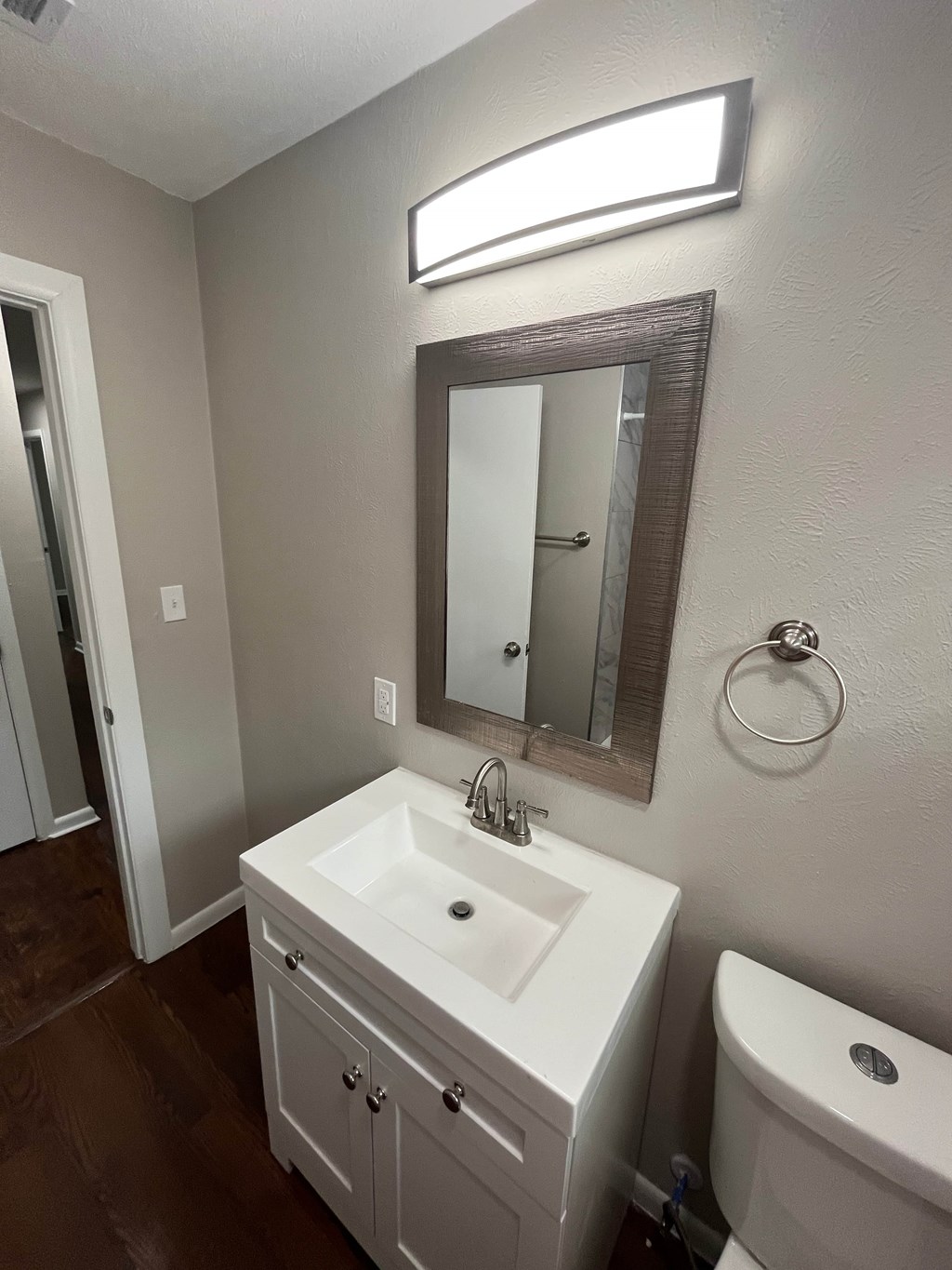 A bathroom with a white sink and a mirror above it.