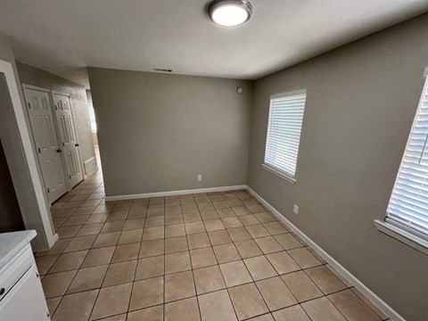 a large empty room with tiled flooring and a closet