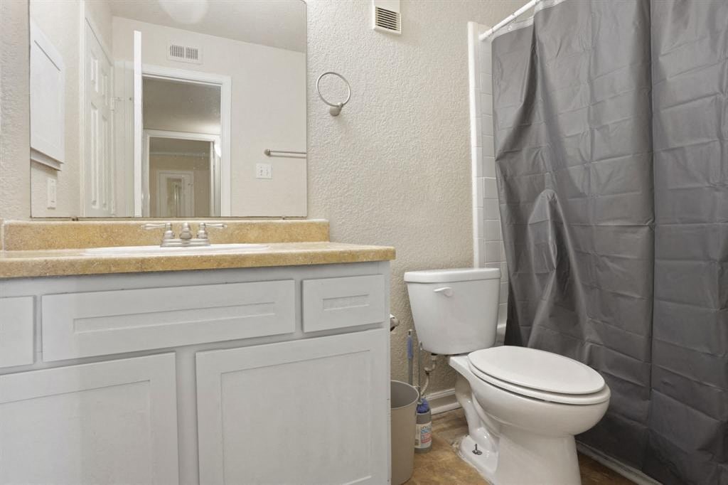 a bathroom with a toilet and a sink and a shower