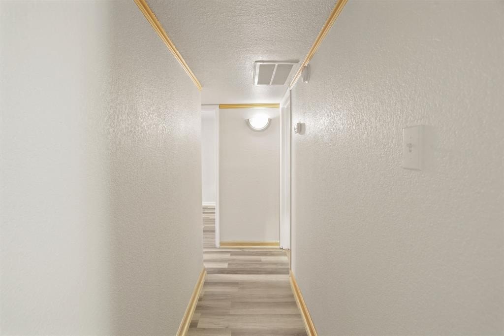 a white hallway with stairs and a white door