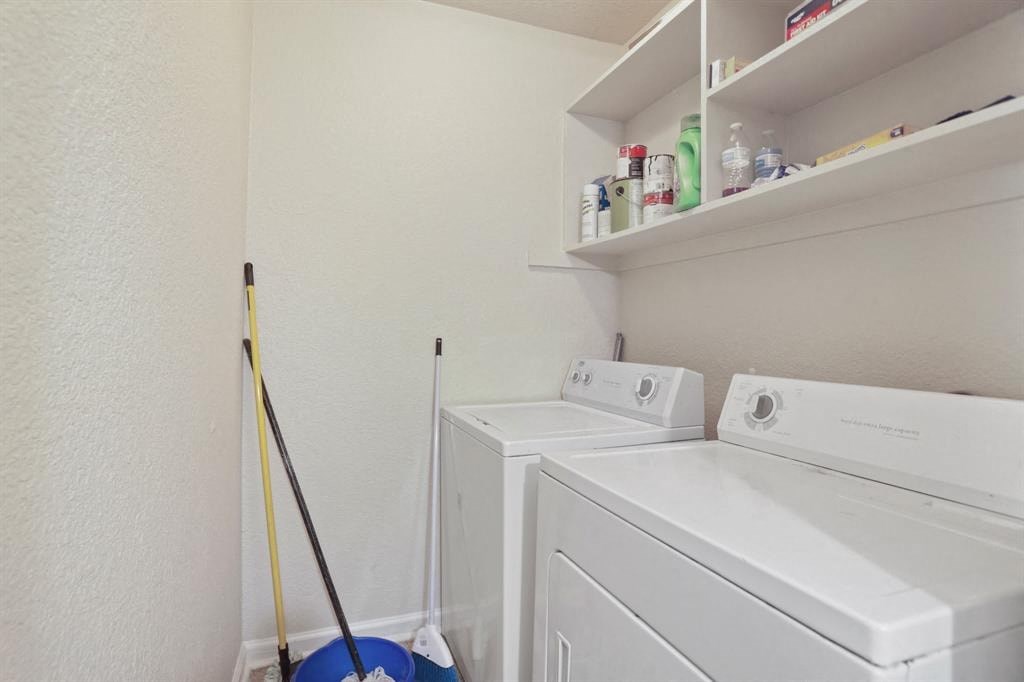 a white washer and dryer in a room with mops