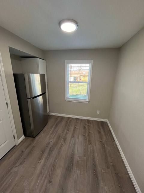A kitchen with a refrigerator and a window.