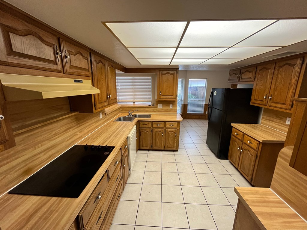 A kitchen with wooden cabinets and black appliances.