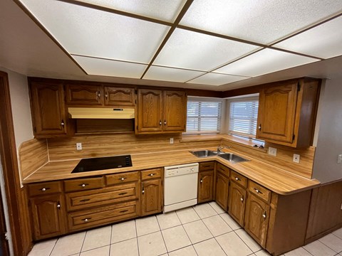 A kitchen with wooden cabinets and a white dishwasher.