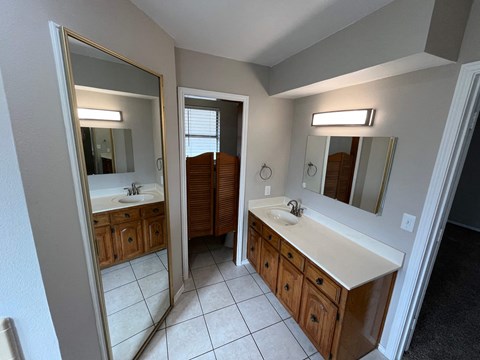 A bathroom with a sink, mirror, and cabinets.