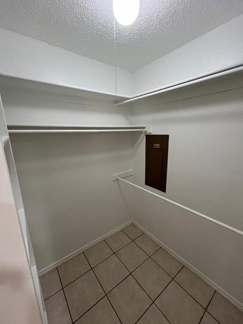A small, empty room with a brown door and white walls.