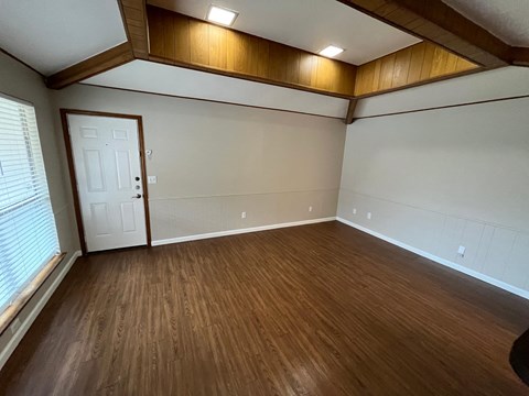 A room with wooden flooring and a white door.