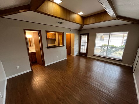A room with wooden floors and a large window.