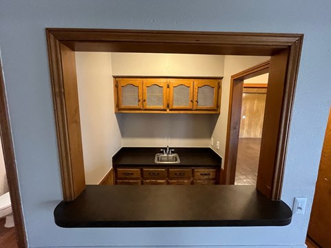 A kitchen with a black countertop and wooden cabinets.