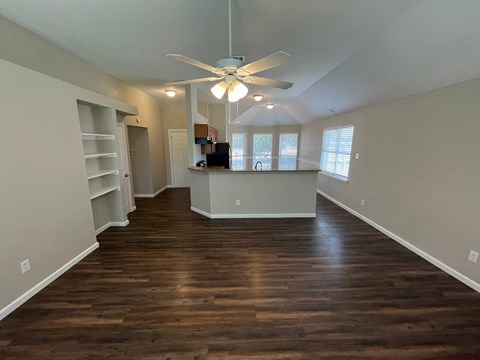 A room with wooden floors and a ceiling fan.
