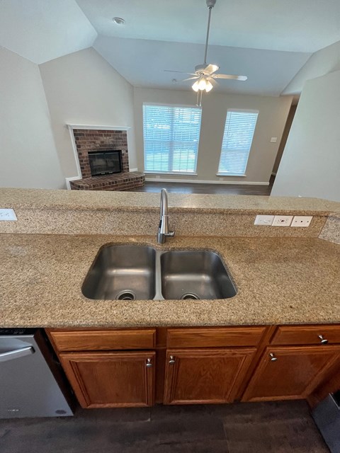 A kitchen with a granite countertop and a double sink.