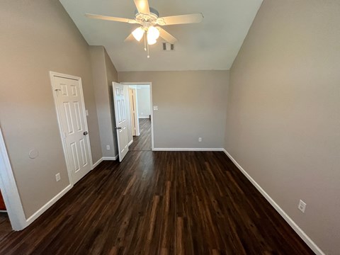 A room with wood floors and a ceiling fan.