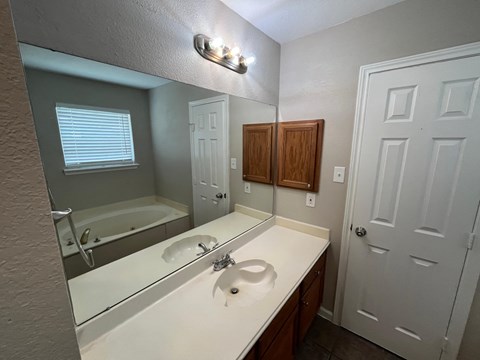 A bathroom with a white sink and a white door.