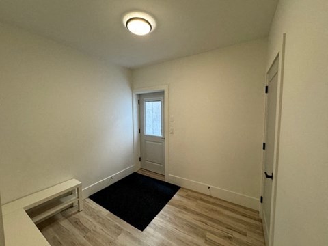 a living room with a door and a black rug