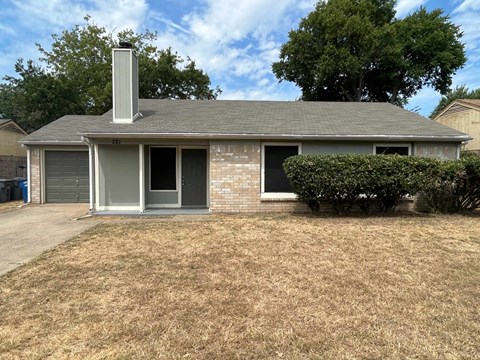 A house with a grey roof and a chimney.