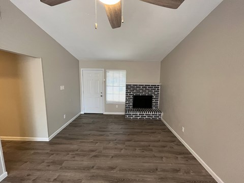 A room with a fireplace and a ceiling fan.