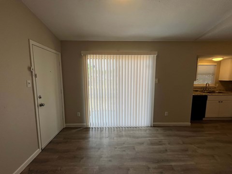 A room with a white door and a window with blinds.
