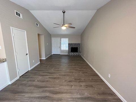 A room with a fireplace and wood flooring.