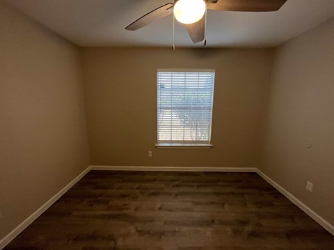 A room with a window and a ceiling fan.