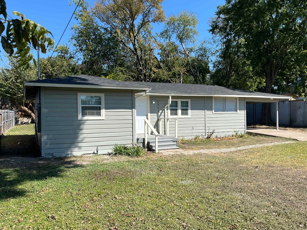 A small house with a grey roof and a white door.