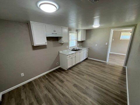 A kitchen area with a white cabinet and a white stove top oven.