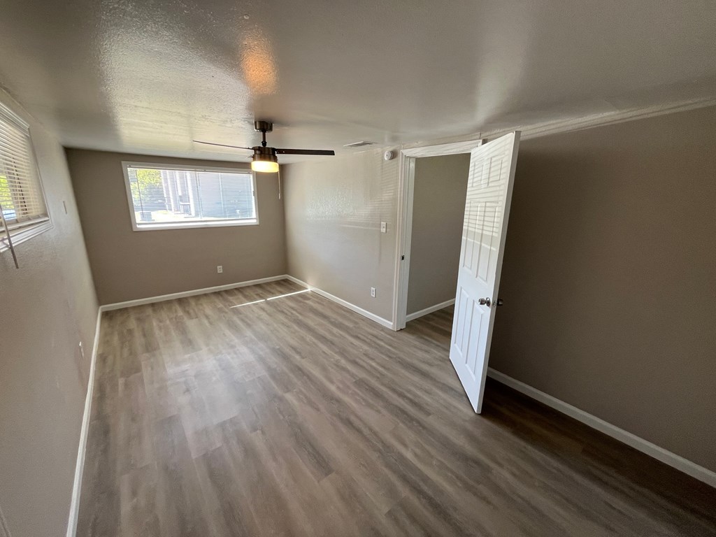 A room with a ceiling fan and a window.