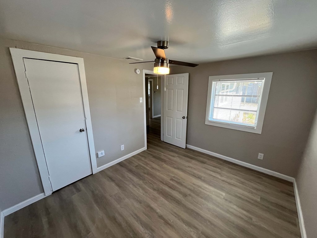 A room with a ceiling fan and a window.