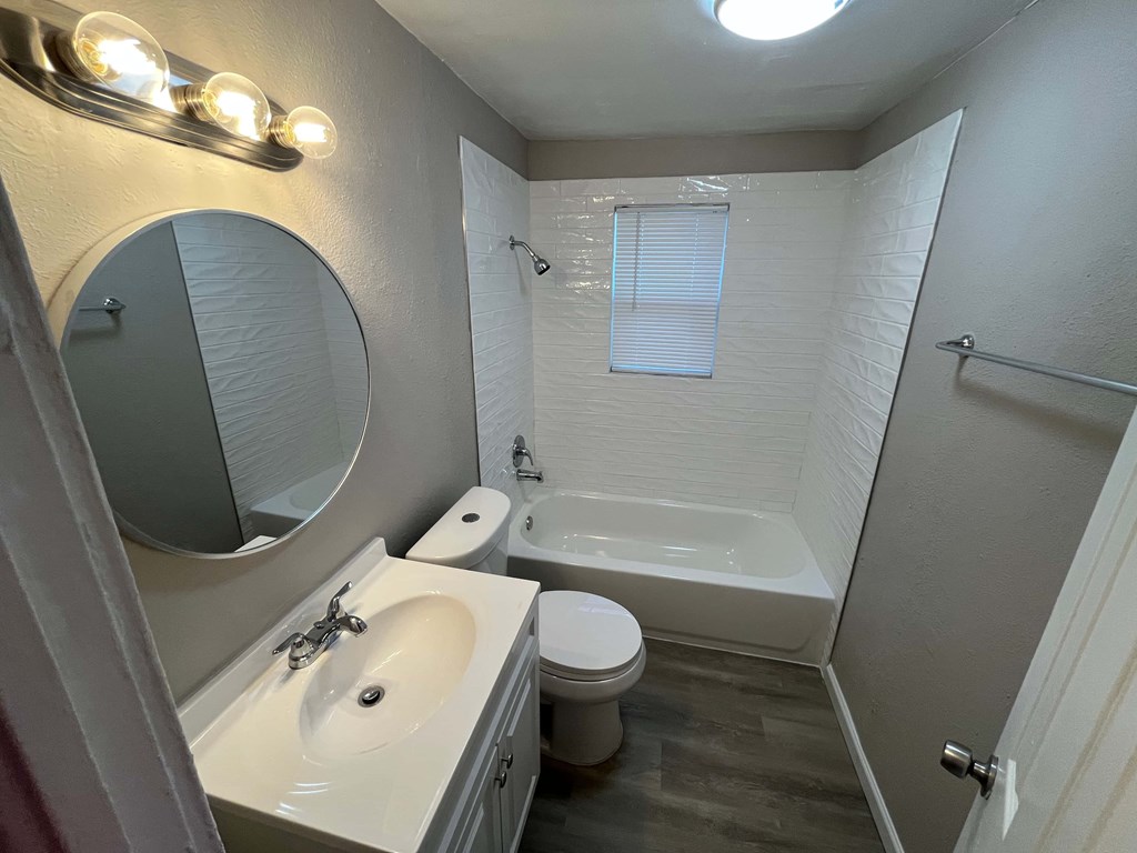 A bathroom with a white sink, toilet, and bathtub.