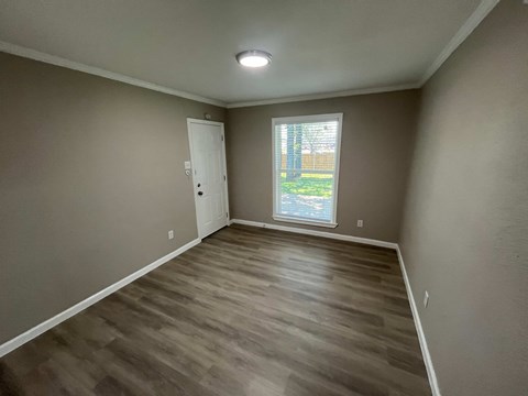 A room with a wooden floor and a window.