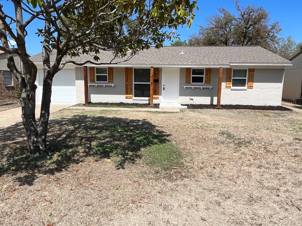 a white house with a tree in front of it
