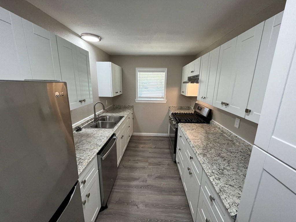 a kitchen with white cabinets and granite counter tops
