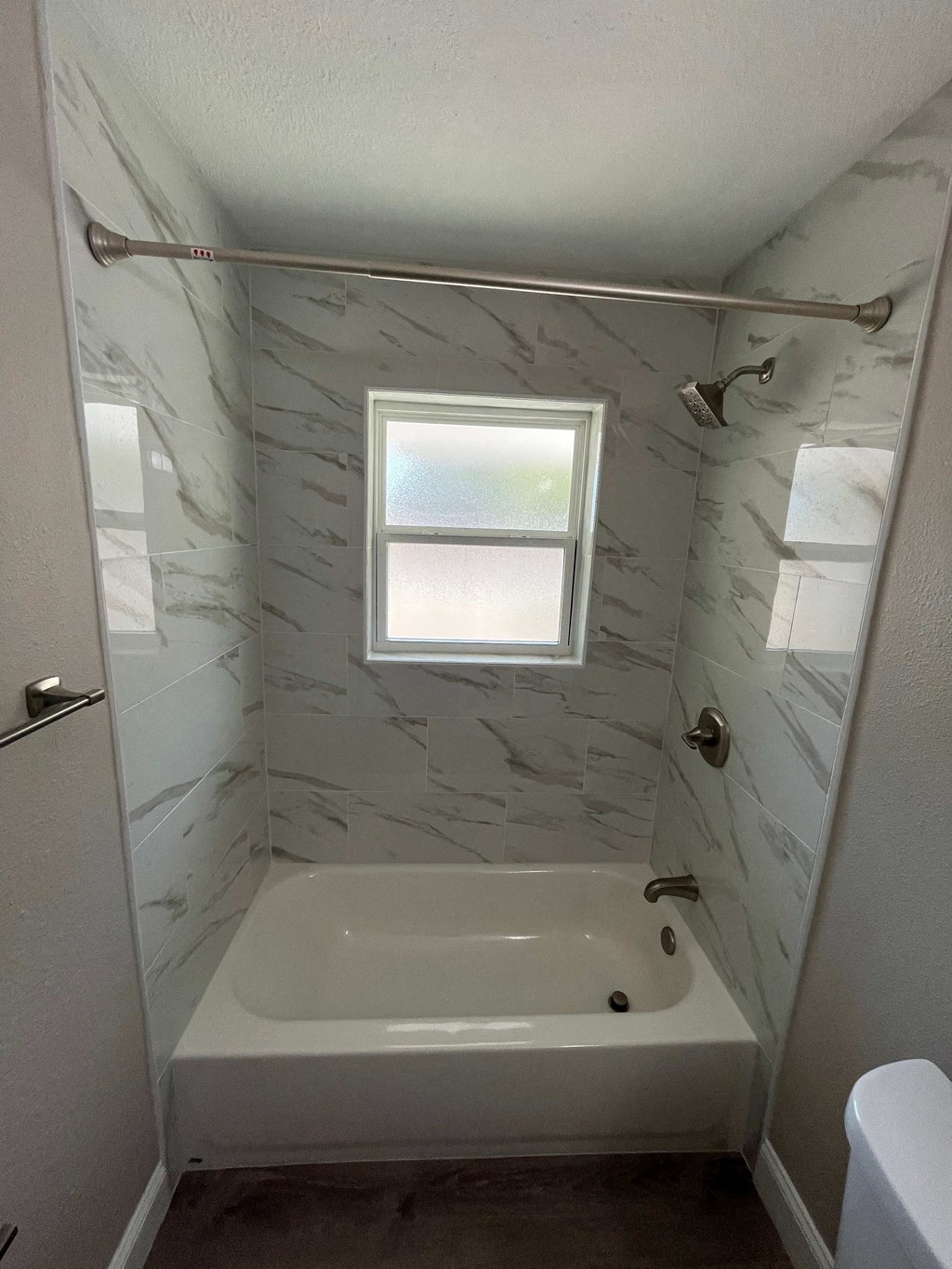 a small bathroom with a tub and a window