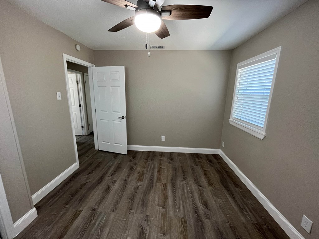 a living room with hardwood floors and a ceiling fan