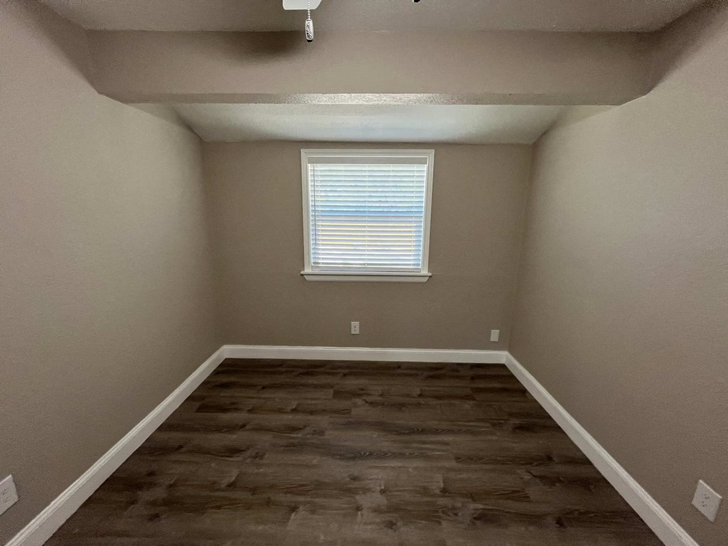 a empty room with wooden floors and a window