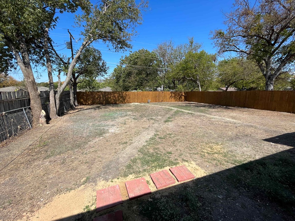 a backyard with a fenced in yard and a fence