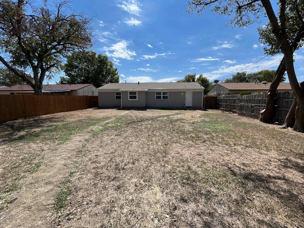a backyard with a house and a fence