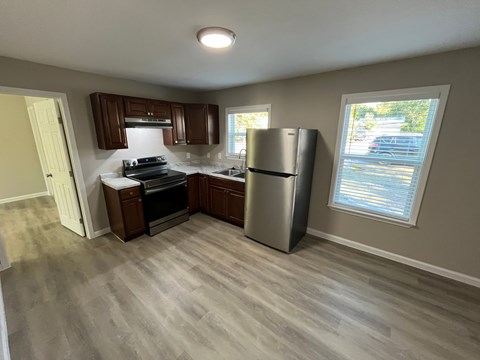 A kitchen with a refrigerator, stove, and dishwasher.