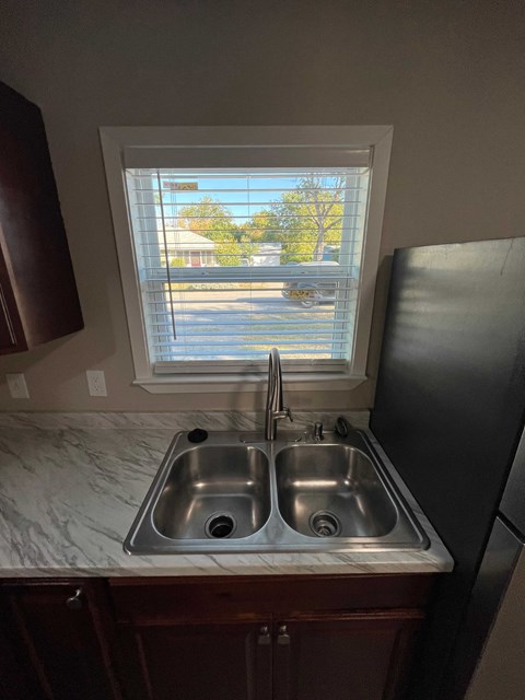 A kitchen with a double sink and a window.