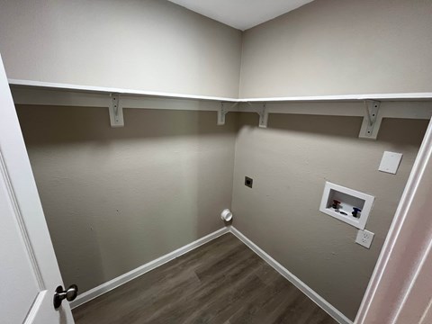 A room with a white door and a grey wall.