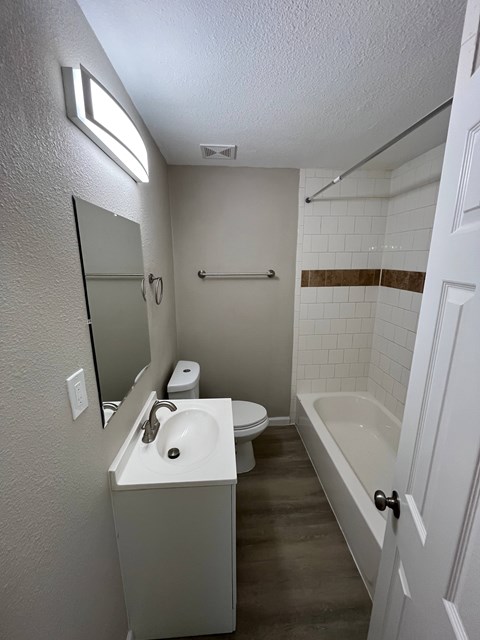 A white bathroom with a toilet, sink, and bathtub.