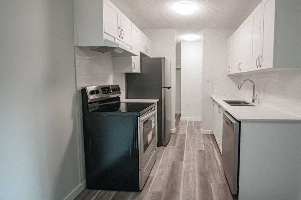 a kitchen with black appliances and white cabinets