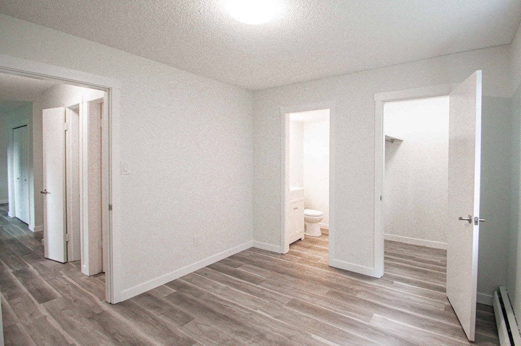 a renovated living room with white walls and wood floors