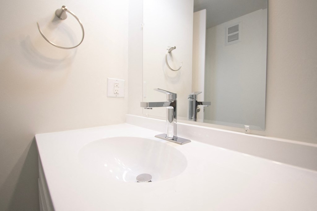 a white bathroom with a sink and a mirror