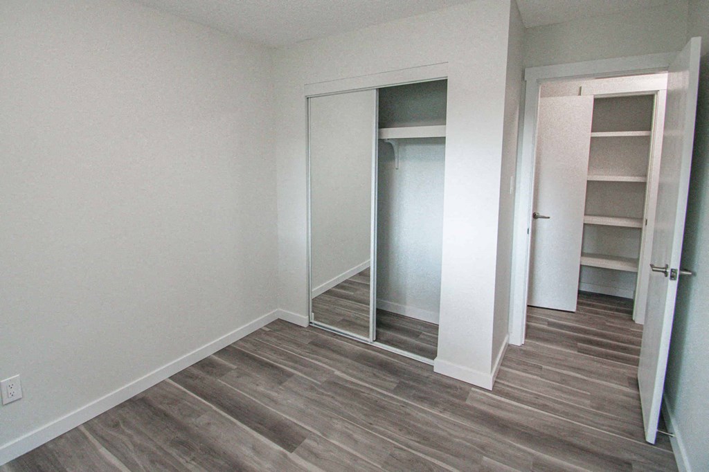 a bedroom with a closet and a hard wood floor