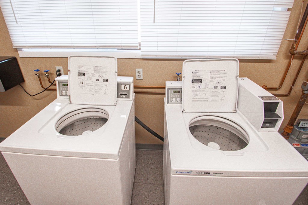 two washing machines sitting next to each other in a room